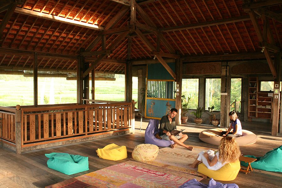 Guests sit on beanbag chairs inside a cabin.